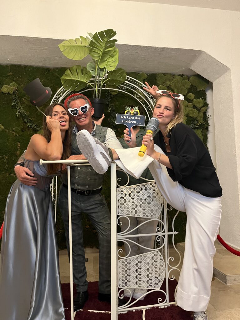 Fotobox für eine Hochzeit gemietet: Brautjungfern und ein Gast posieren mit lustigen Requisiten.